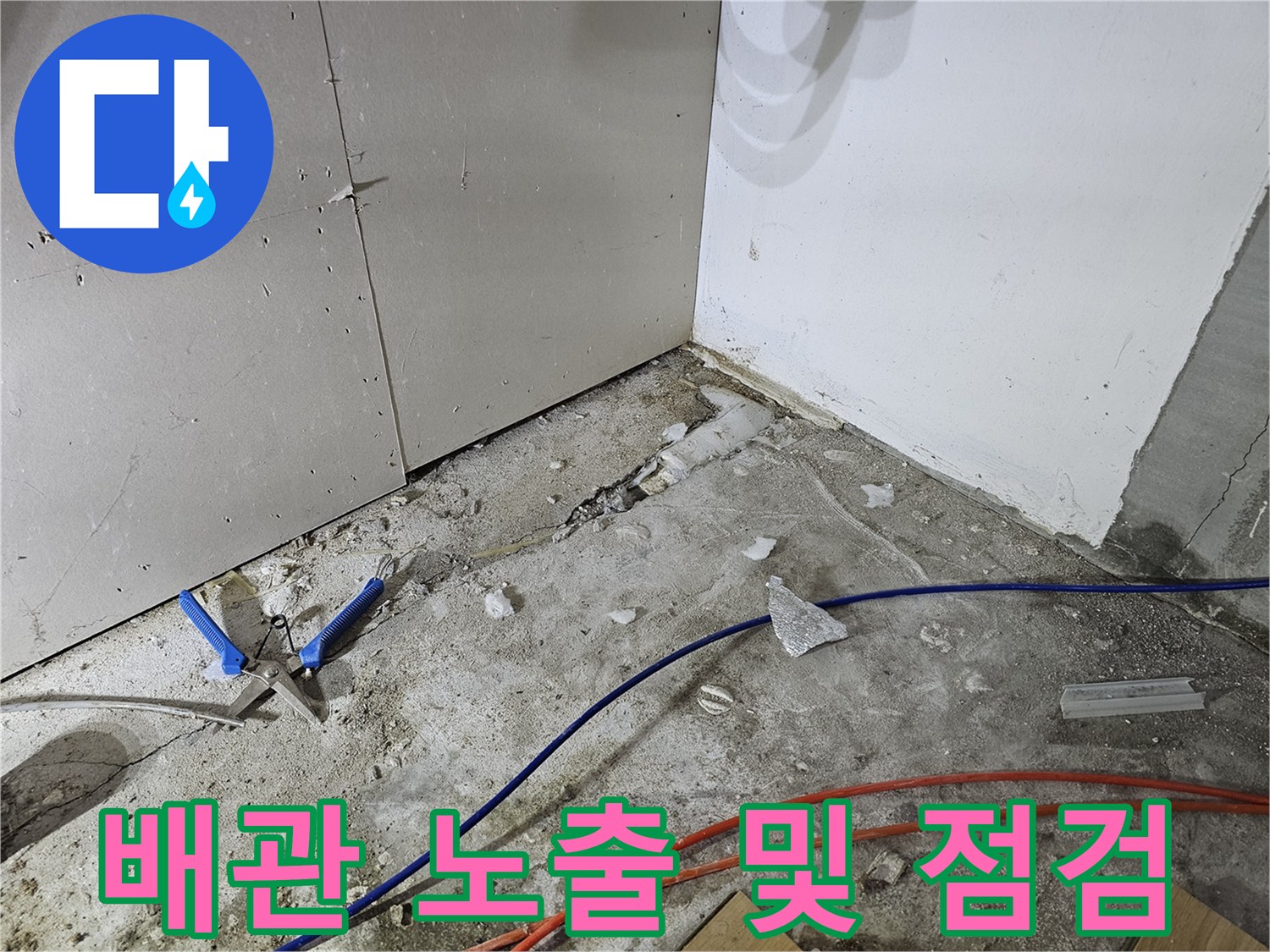 싱크대 아래쪽-굴착된 바닥 사이로 드러난 수도 배관과 주변 자재들