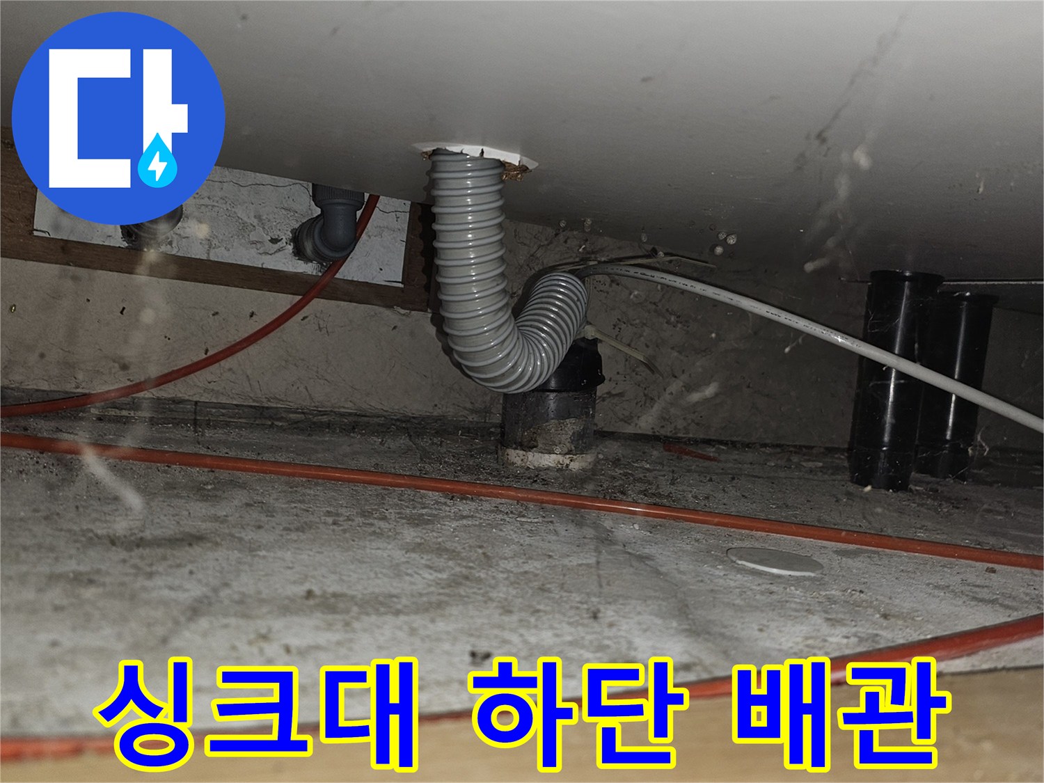 주방 싱크대 밑-회색 주름관과 붉은 전선의 배치