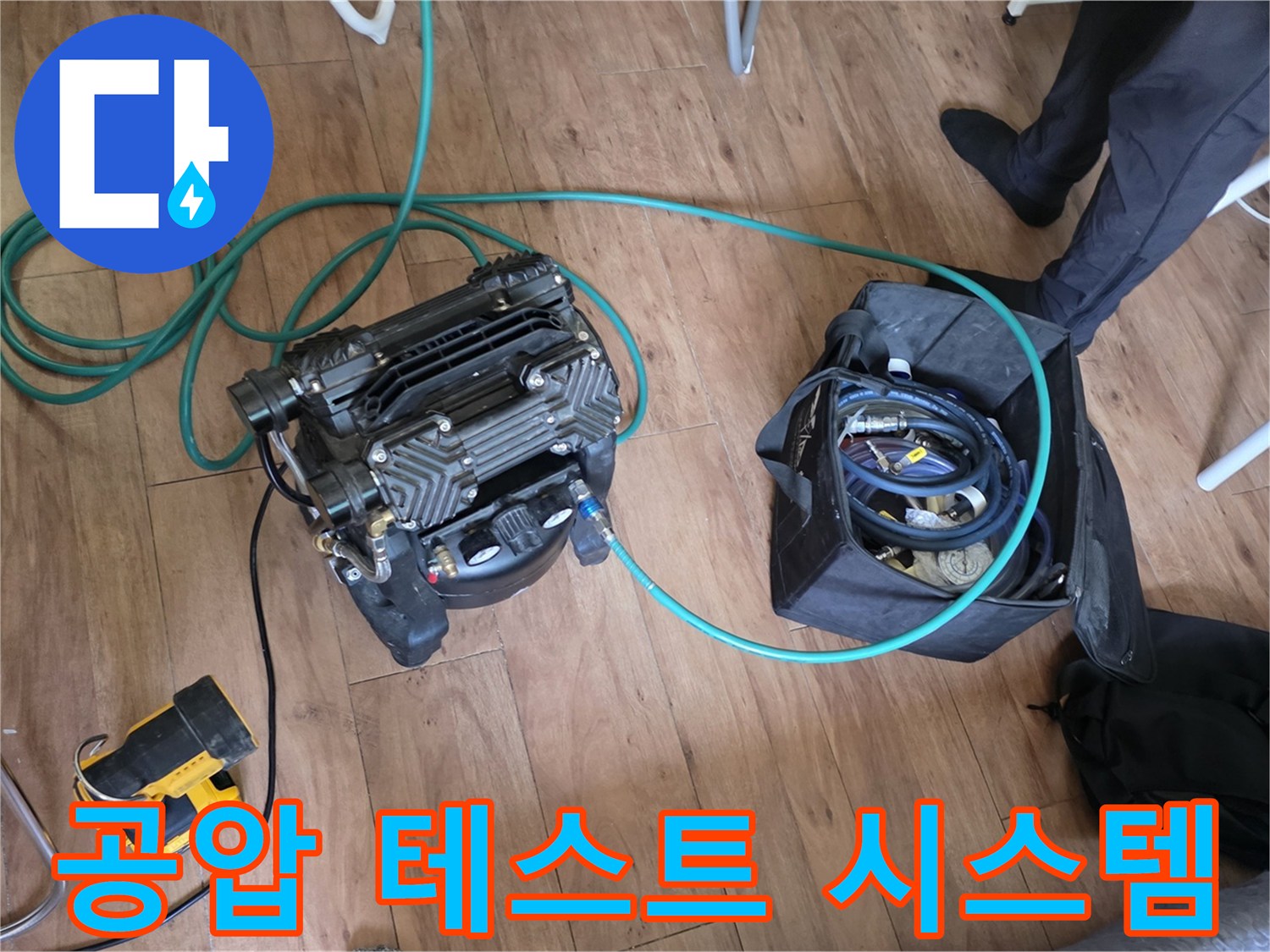 현장에서 사용 중인 공기 압축기와 연결 호스의 모습