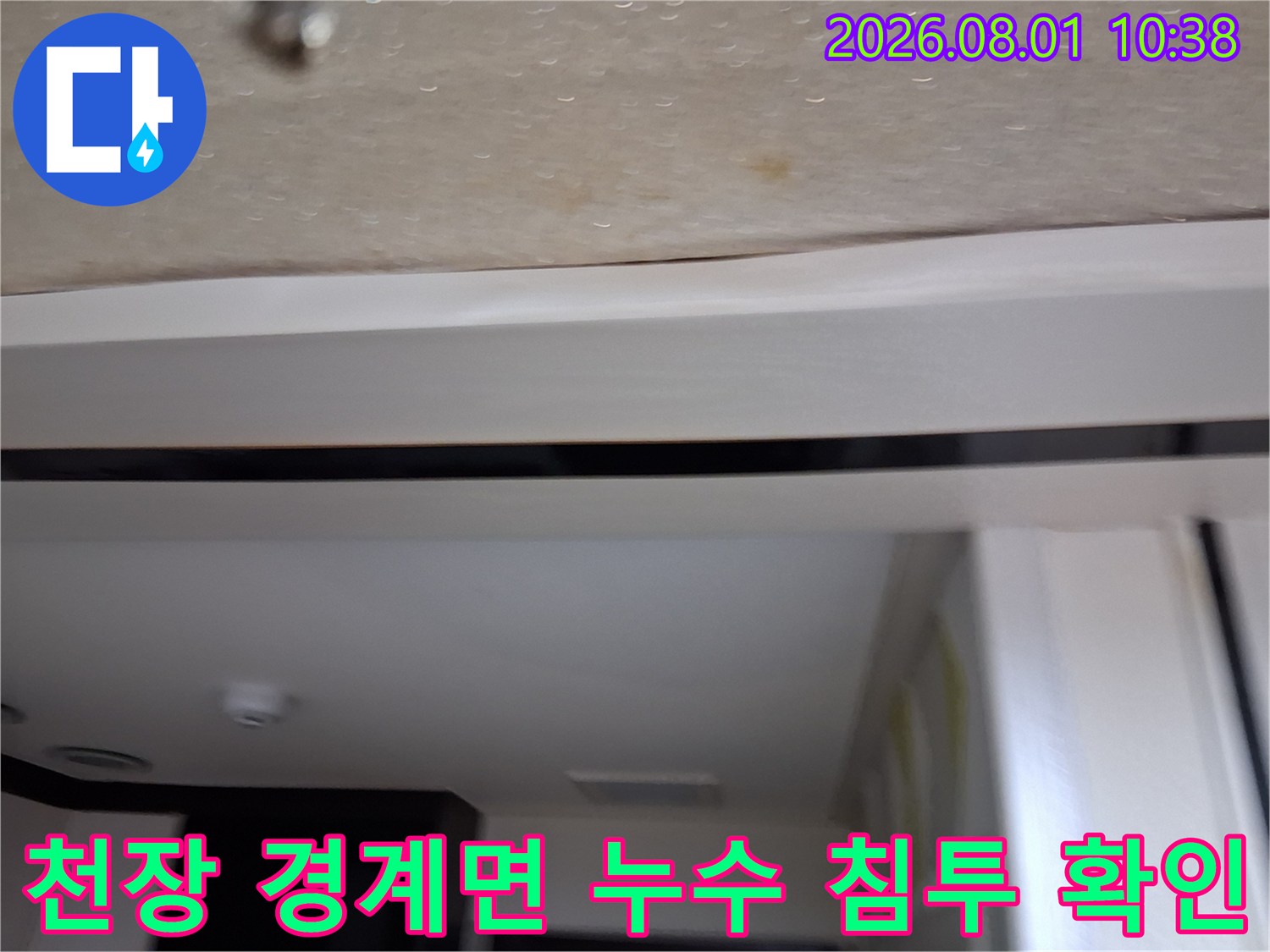 화장실 입구 천장 마감재가 물을 머금어 변색된 모습의 사진