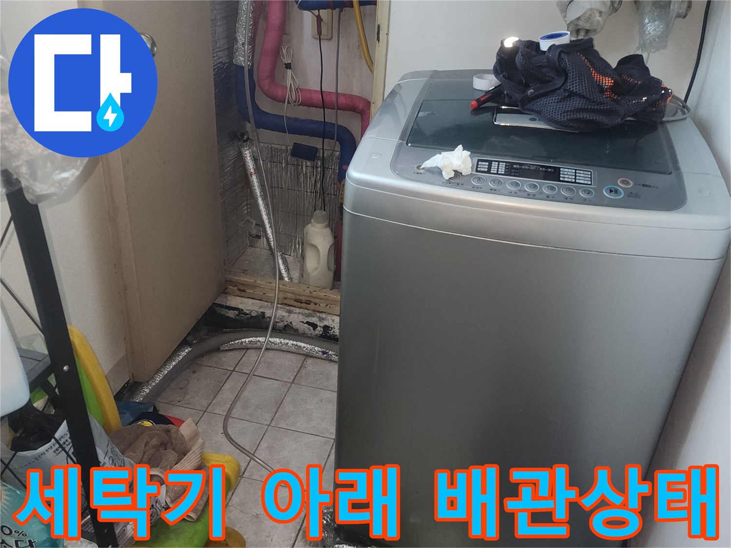 세탁기 하단에 위치한 노출 배관과 보온재 마감 상태를 보여주는 사진
