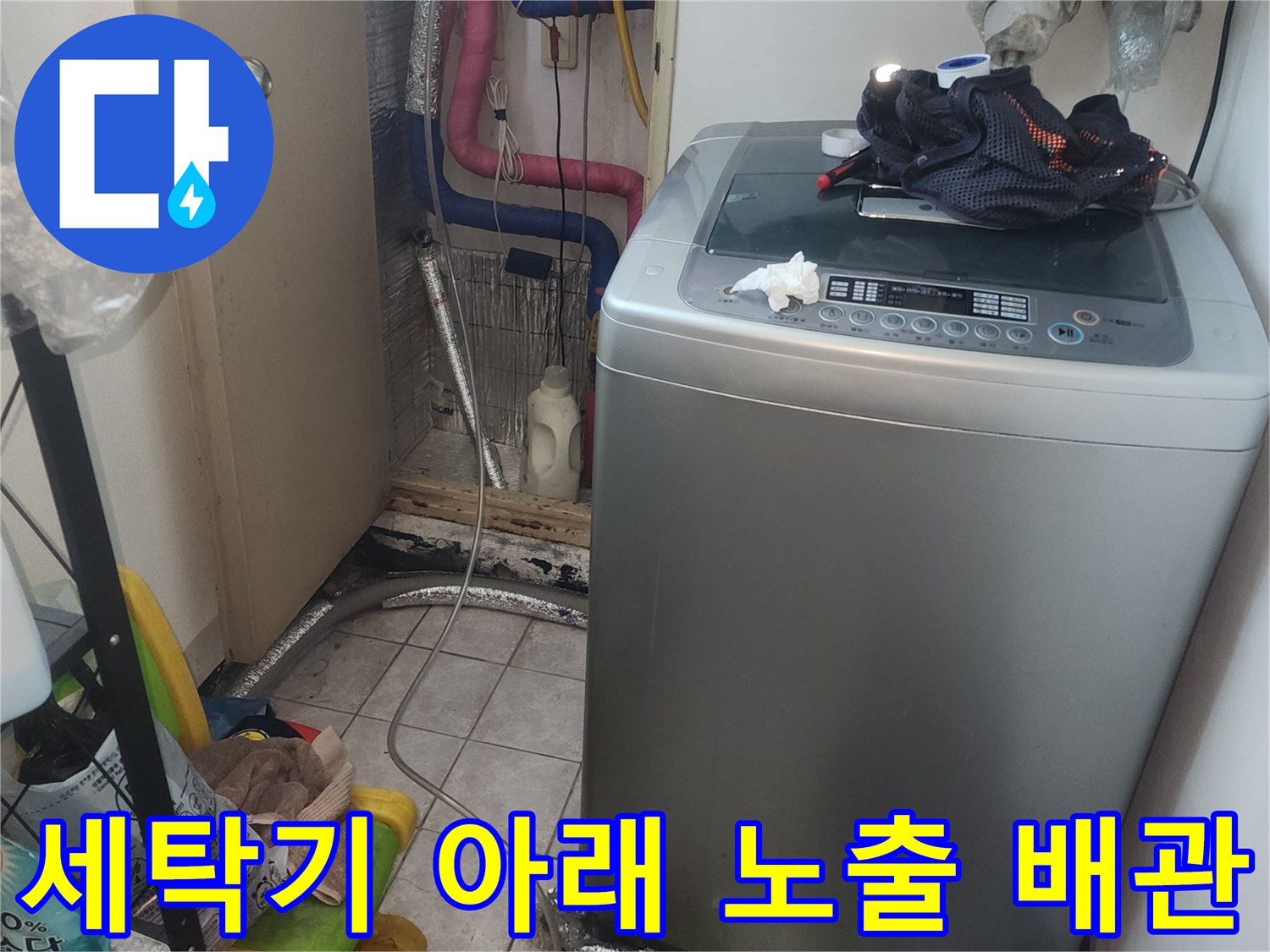 세탁기 하부의 여러 갈래로 나뉜 급수 및 배수 배관 사진