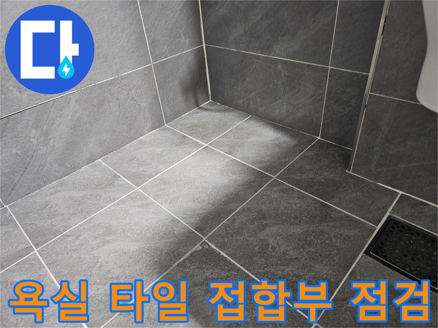회색 욕실 타일의-줄눈과 배수구 근처 마감 상태를 나타냅니다.
