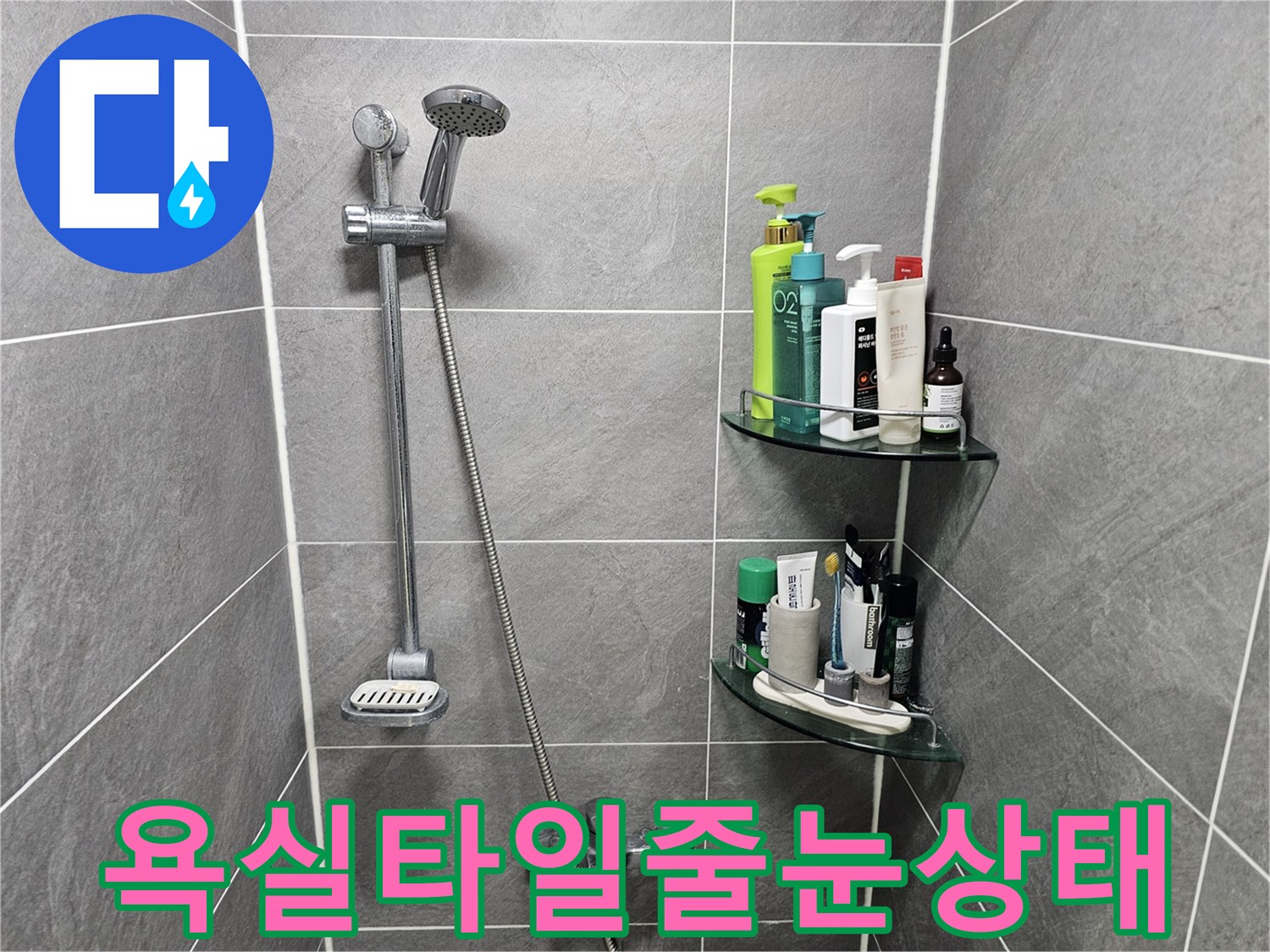 회색 타일 사이의 흰색 줄눈과 샤워 시설