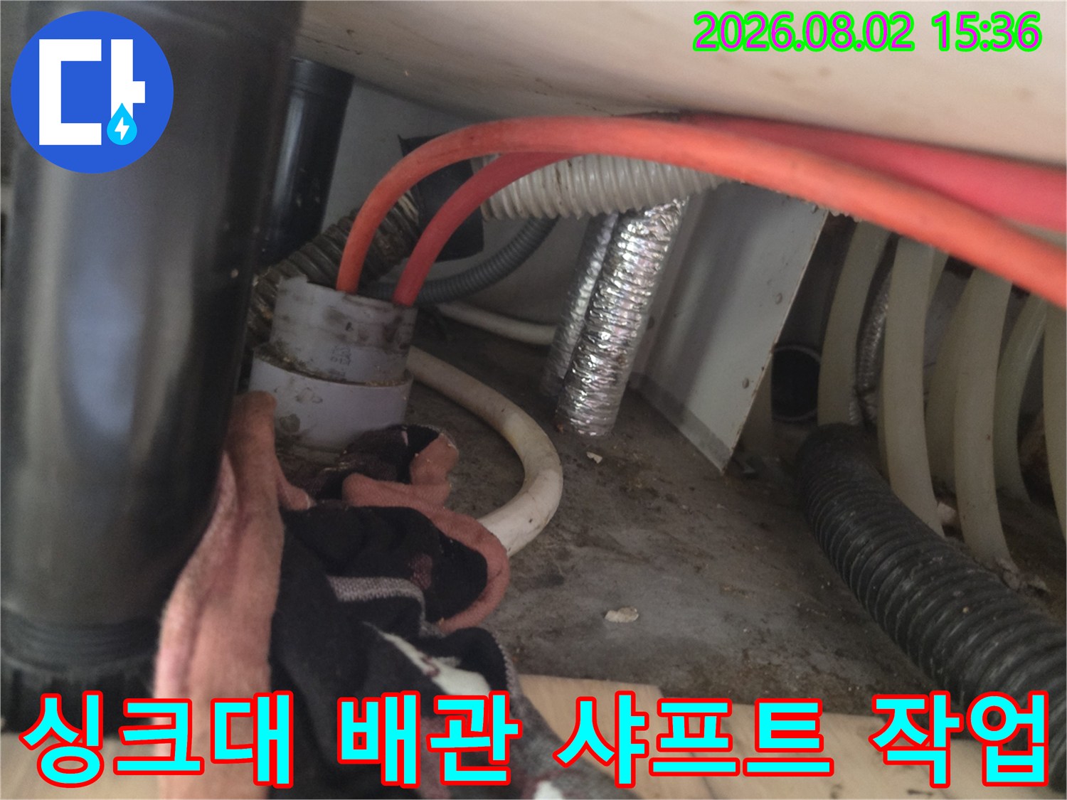 싱크대 하부장 안쪽의 배수관을 청소하는 장비와 배관 구조물