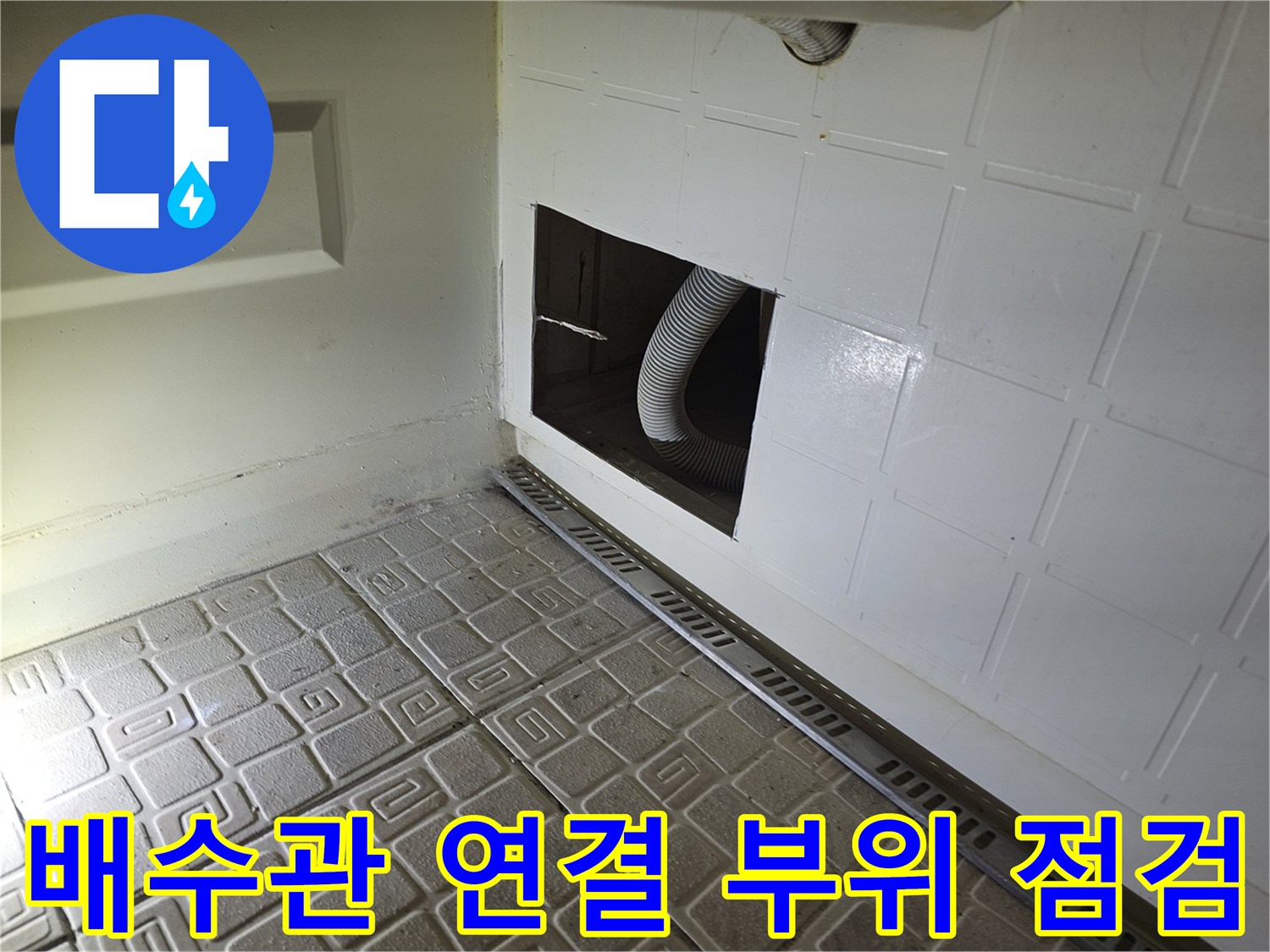 타공된 공간 내부의 주름진 자바라 호스 및 하부 구조물