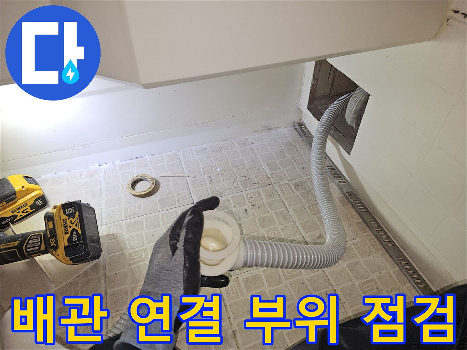 타공된 욕조 벽면 사이로-길게 연결된 하얀색 배수 호스