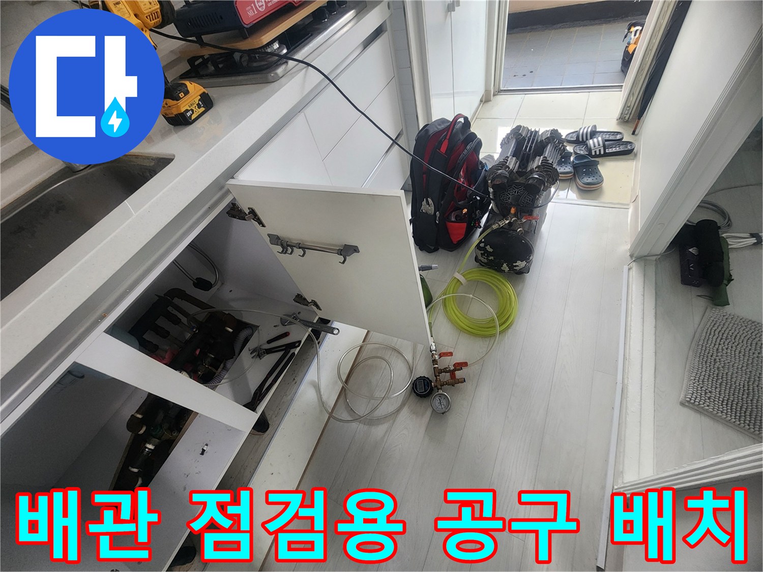 누수 지점 추적을 위해 싱크대 하부장에 정리된 전문 검사 장비들