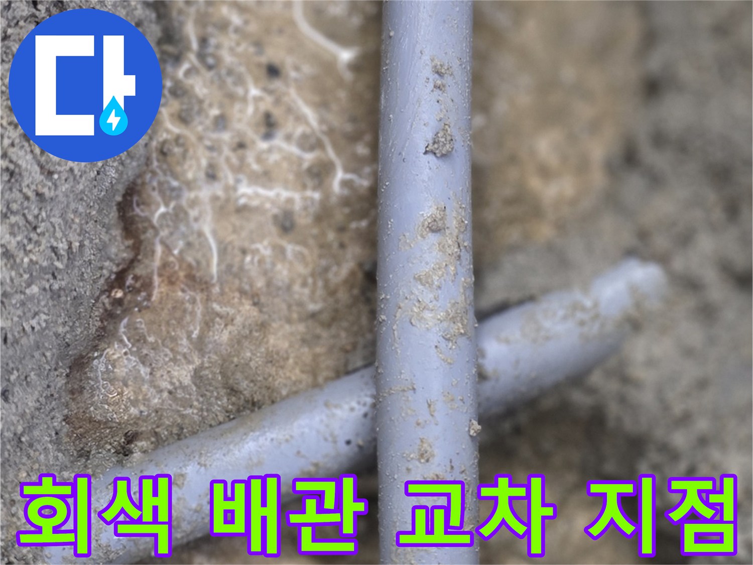 엇갈려 있는 두 개의 회색 수도 배관-공사 현장 사진
