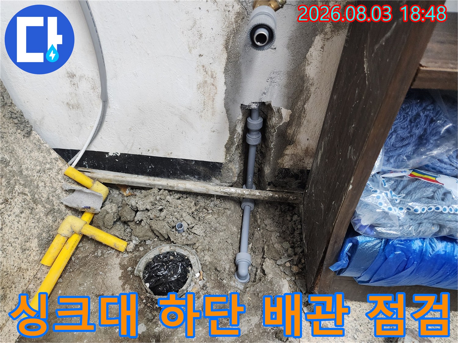 누수가 발생한 싱크대 아래쪽의 노출된 배관 및 주변 환경 사진