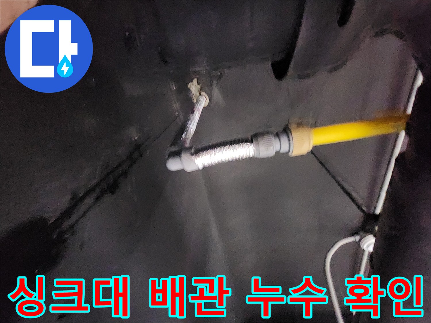 천안 동남구 싱크대 하부장 내부의 노후된 배관과 습기가 찬 벽면 상태