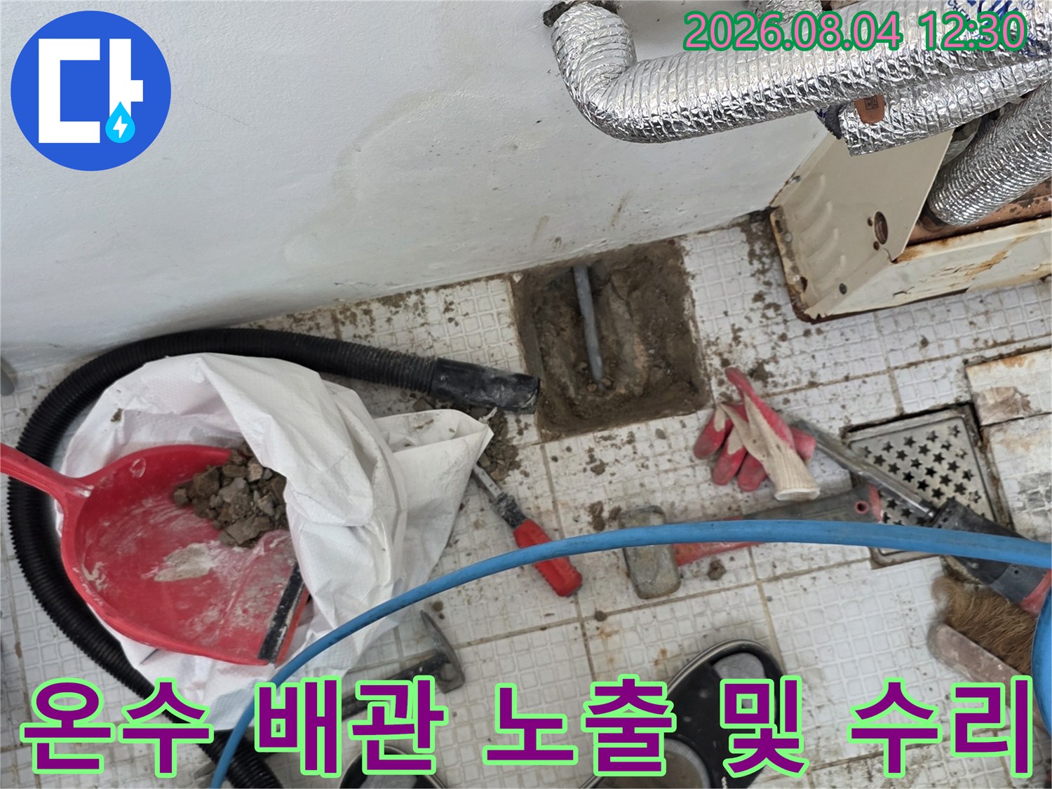 노출된 온수 배관과 작업용 도구들이 배치된 공사 현장 모습
