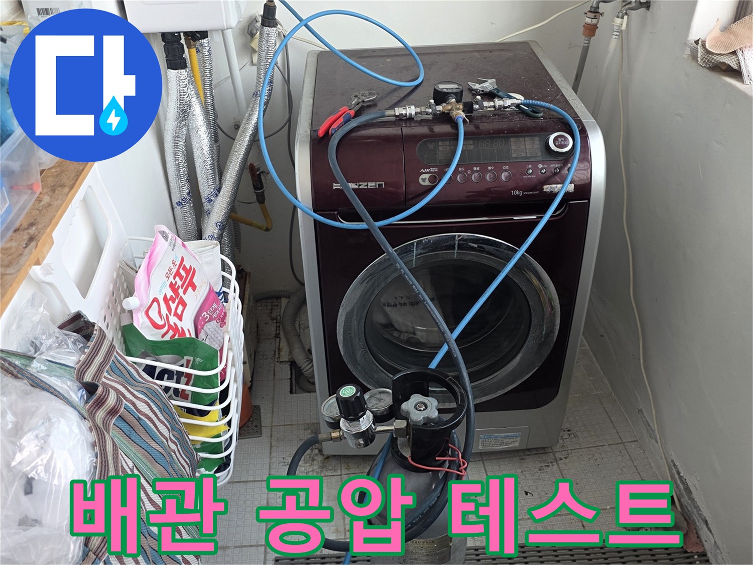 세탁실 벽면에 설치된 배관 압력 측정용 게이지와 호스