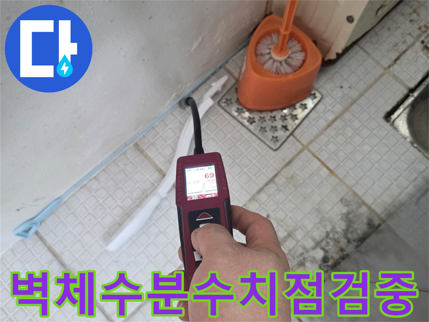 세탁실 벽면에-함수율 측정기를 대고 누수 지점을 찾는 모습