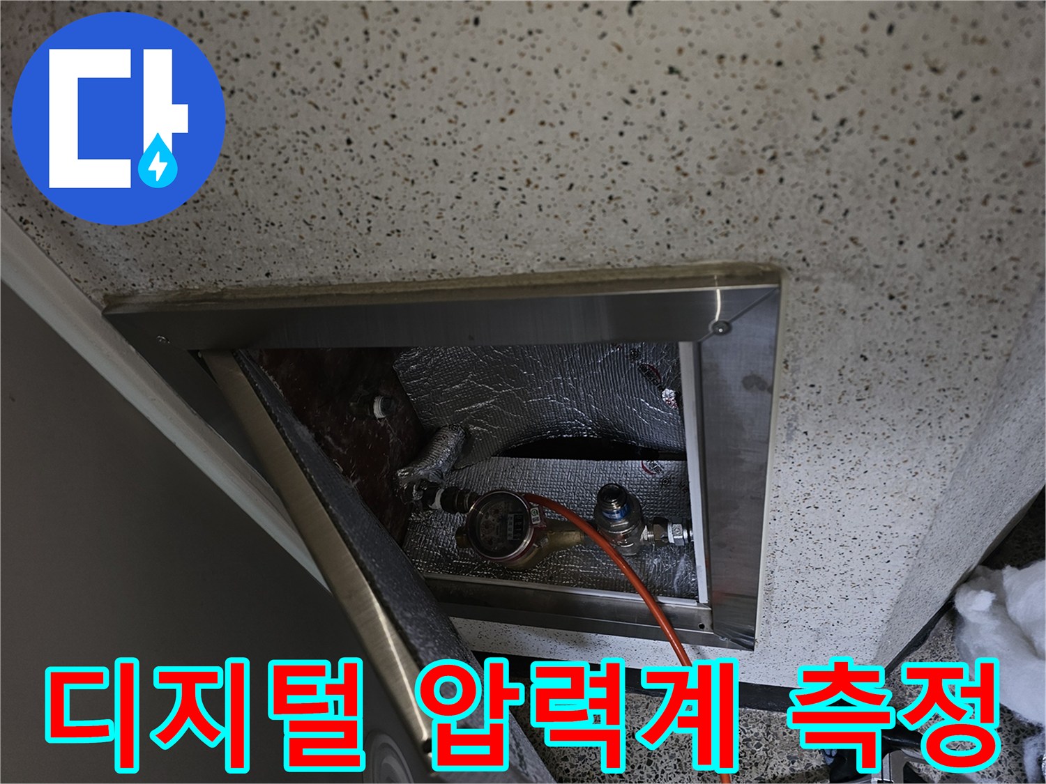점검구 내부 배관-압력 측정을 위해 연결된 장비와 호스