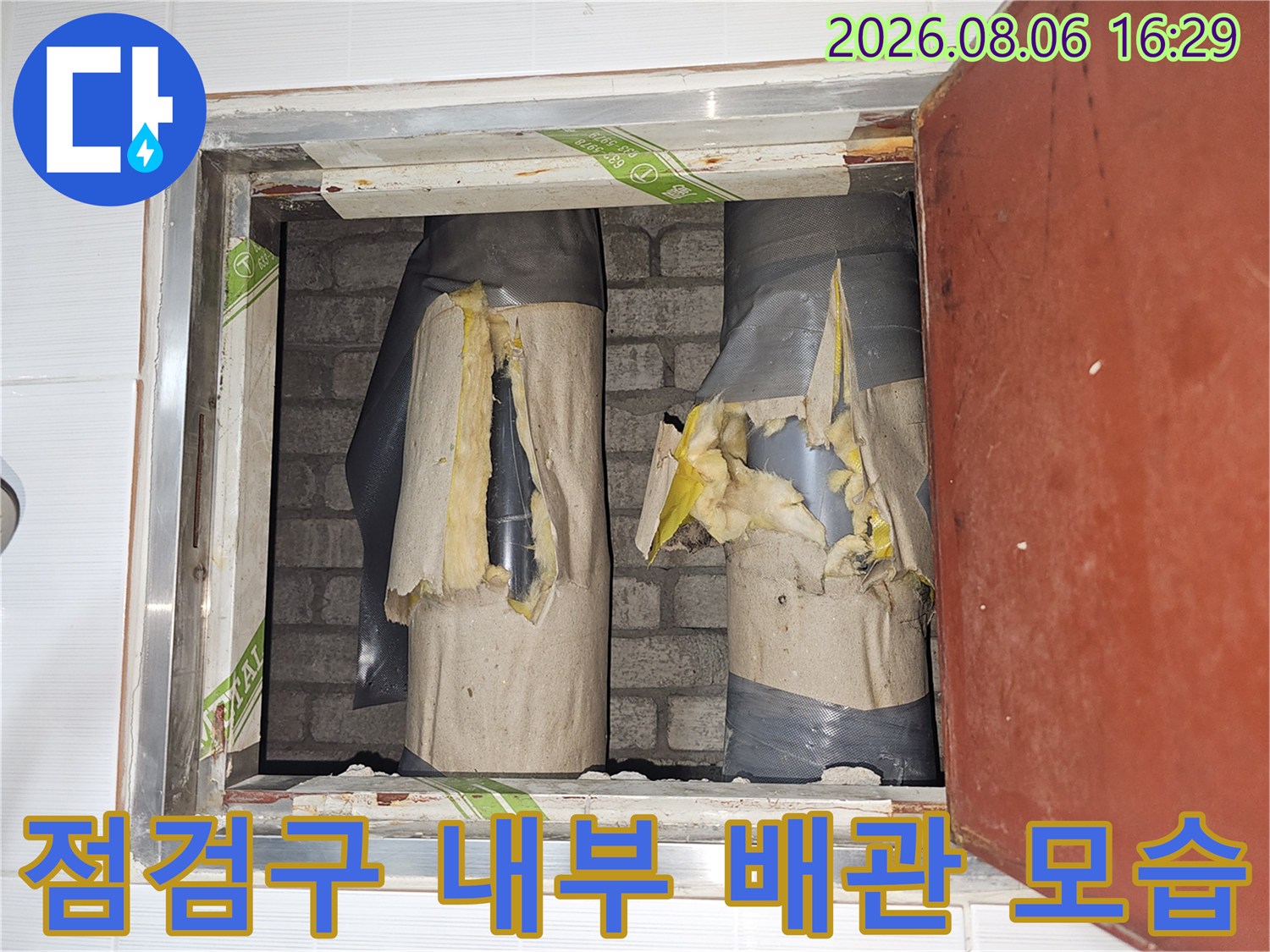 화장실 점검구-보온재가 입혀진 배관 구조