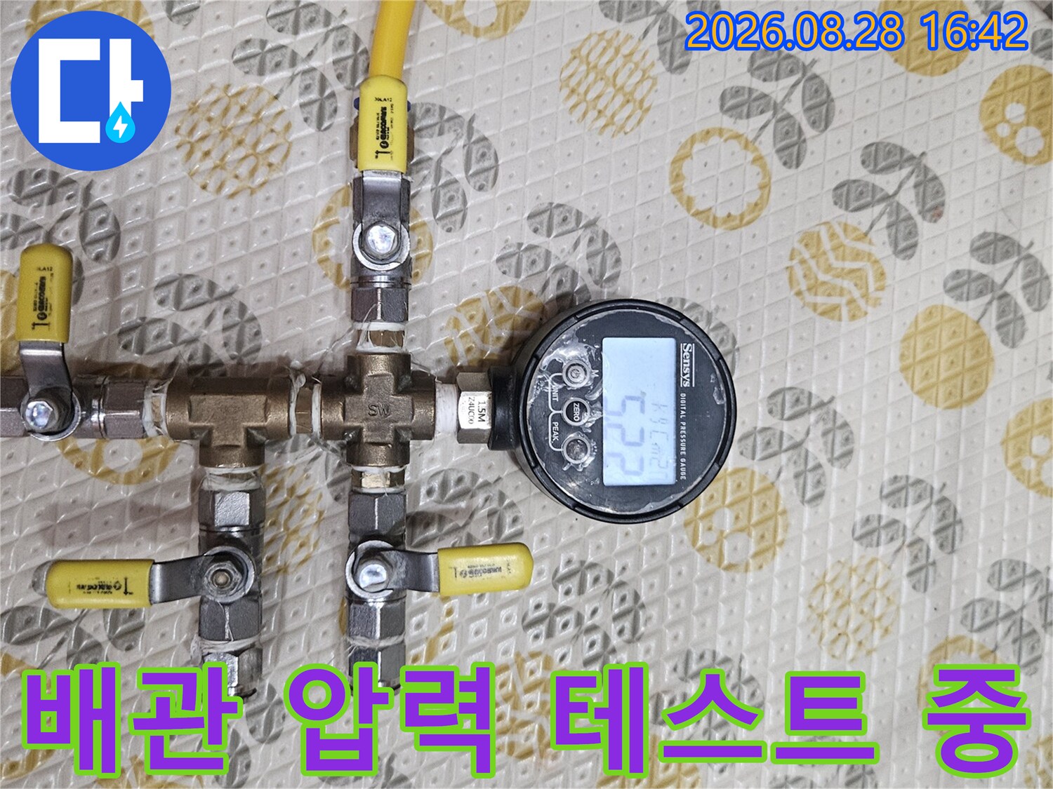 노란색 호스와 밸브가 연결된 배관 압력 측정 장비 사진입니다.