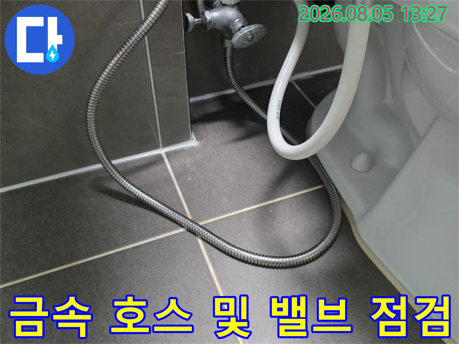 양변기 하단부에 노출된 금속 재질의 급수용 유연관과 연결 부위 상세 확인