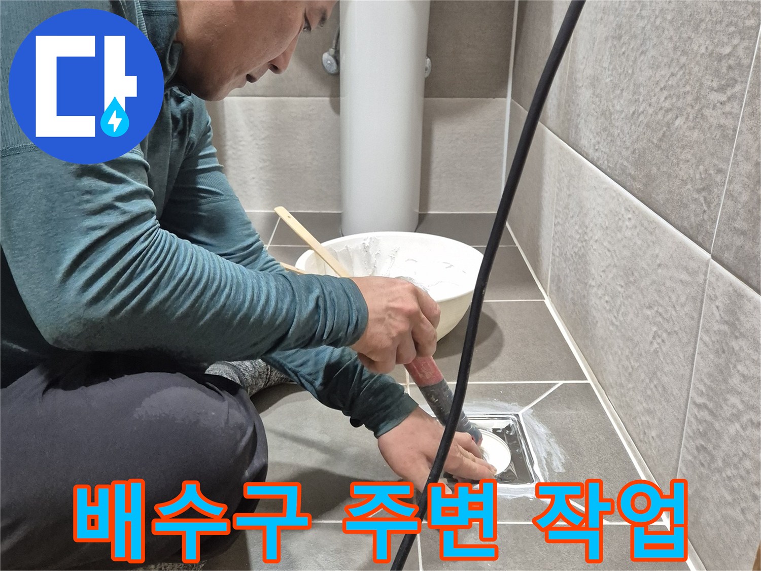 욕실 배수구 주변의 타일 틈새를 점검하는 모습