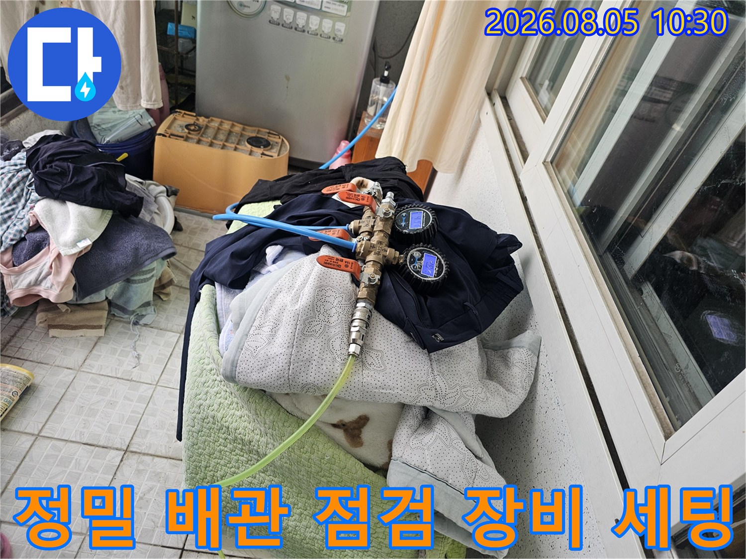 베란다 공간에서 배관에 연결된 호스와 게이지로 누수를 정밀 탐지함
