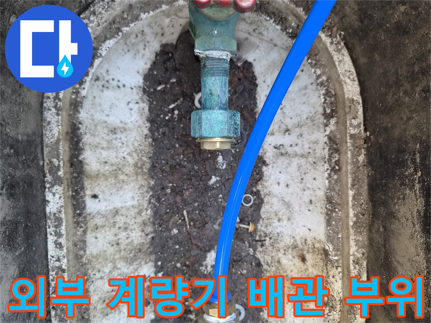 계량기 함 내부의 빨간색 밸브와 파란색 호스가 연결된 모습입니다.