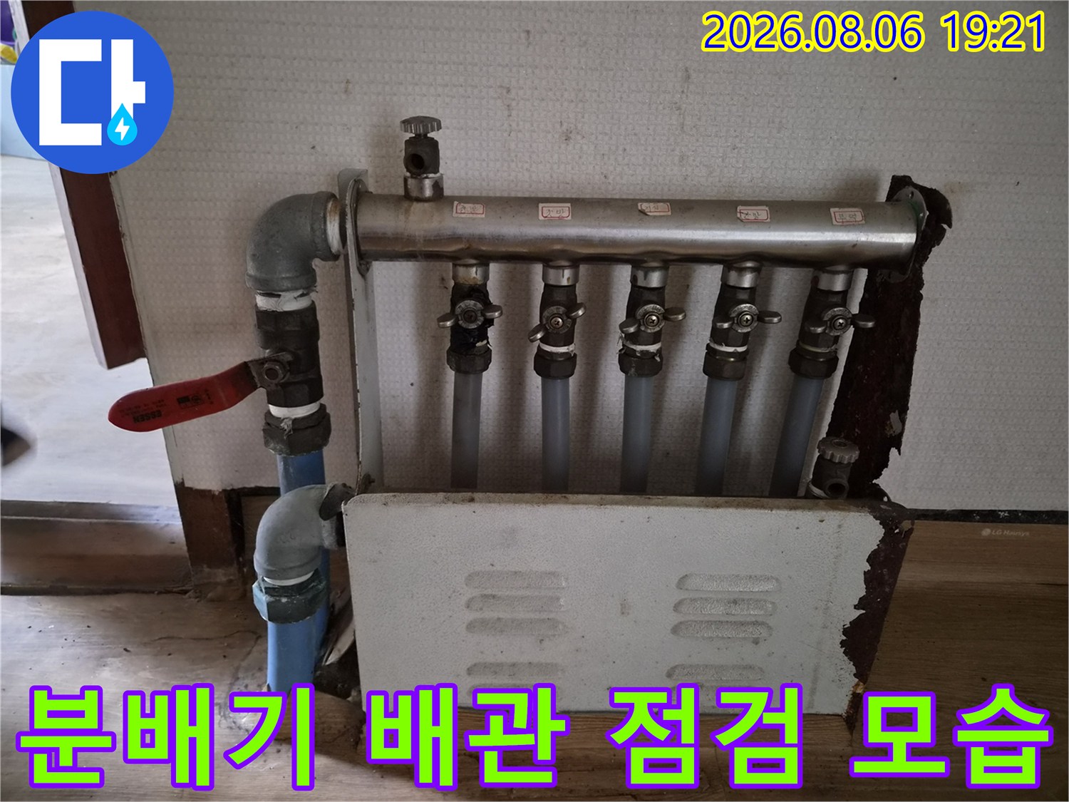 벽면이 뜯겨진 공간에 노출된 분배기와 배관 세부 점검 장면