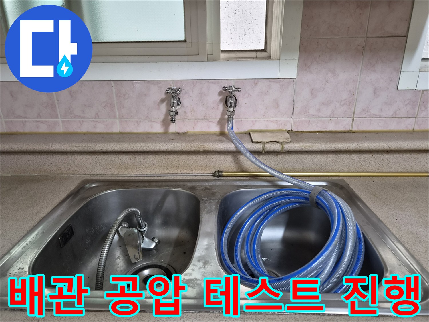 싱크대 수전 밸브에 연결된 파란색 호스와 에어 압력 테스트 장비
