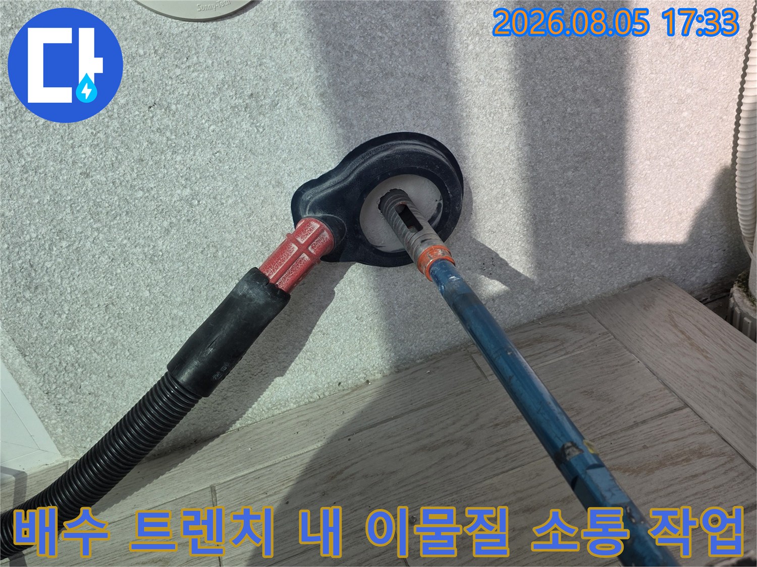 특수 장비를 사용하여 배출구가 막히지 않도록 내부를 청소하는 세탁실 공사 현장