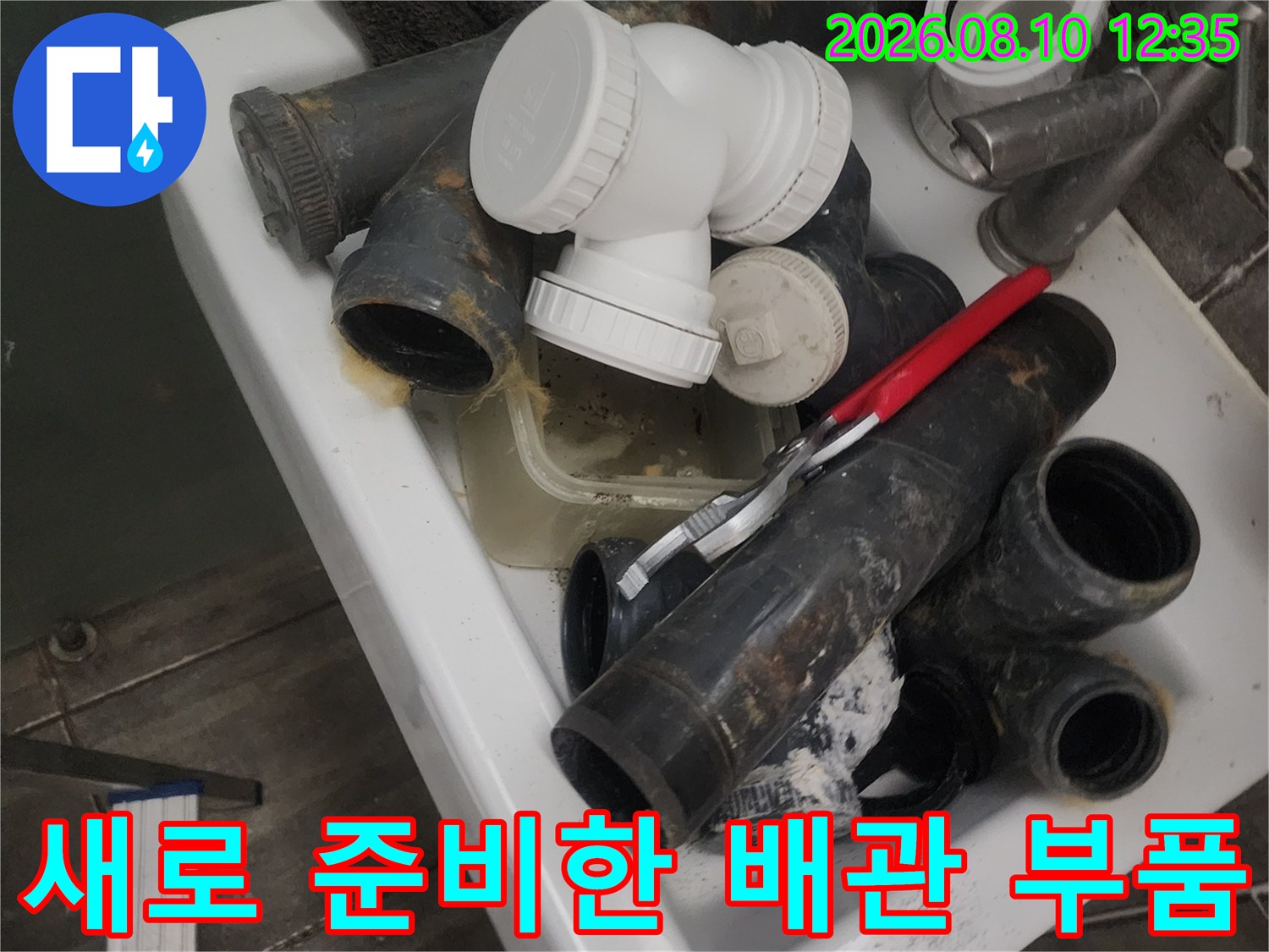 교체 공사를 위해 세면대에 가지런히 놓인 하수 배관 자재들입니다.