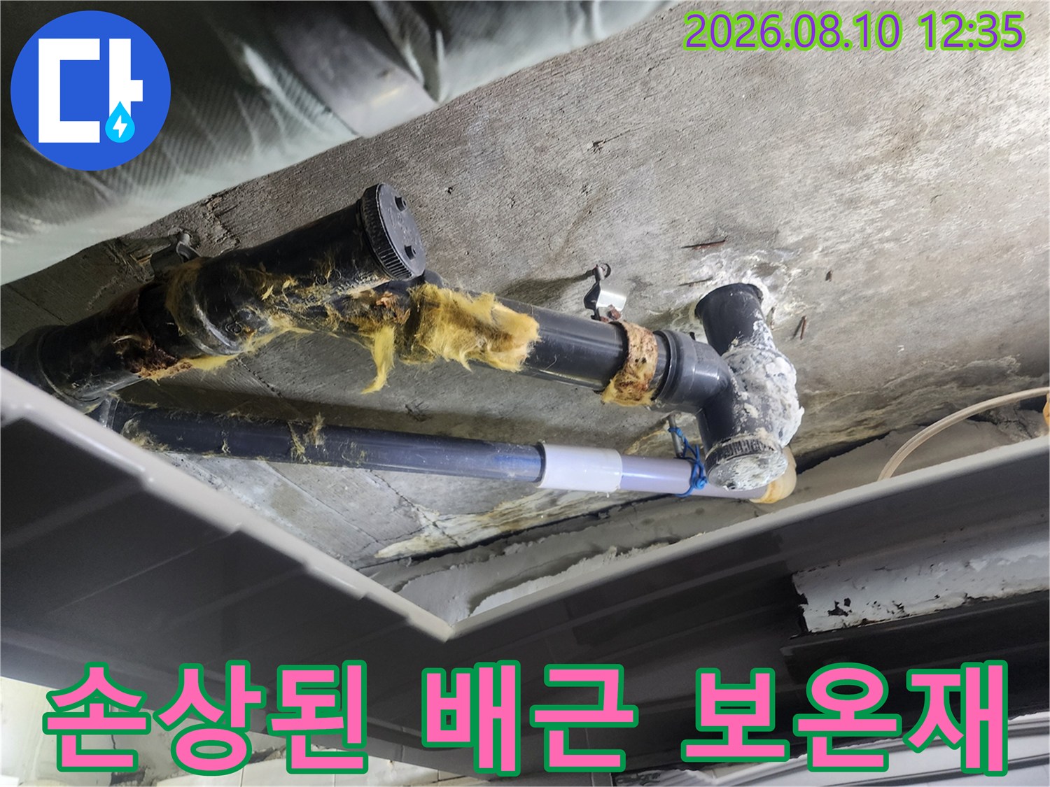 벗겨지고 오염된 배관 보온재와 하수관 연결 부위를 촬영한 사진입니다.