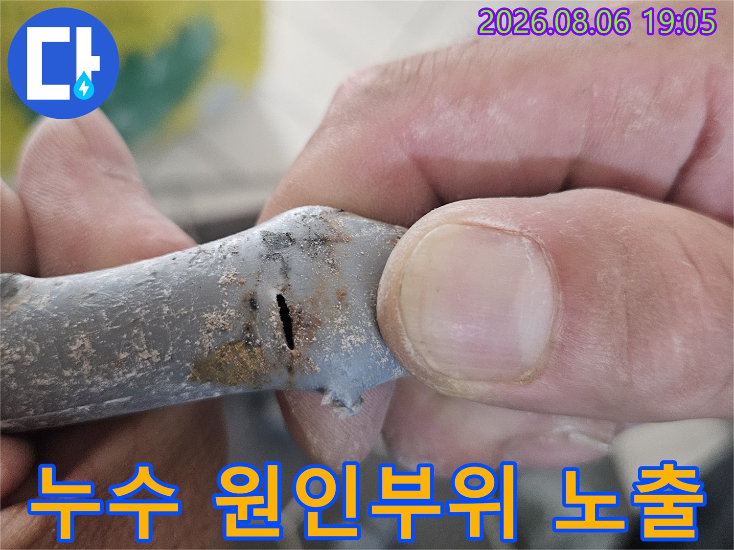 손에 든 배관의 균열 부위를 근접하여 촬영한 누수 진단 사진