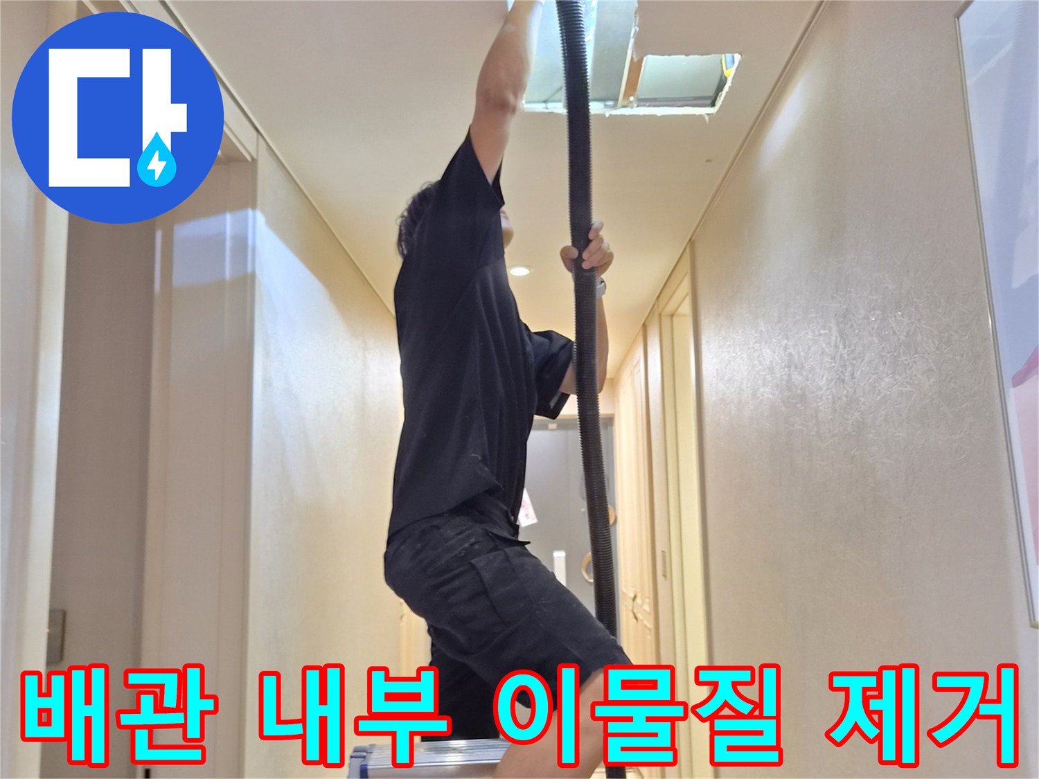 사다리에 올라가-천장 배관 내부의 막힌 구간을 청소하는 모습