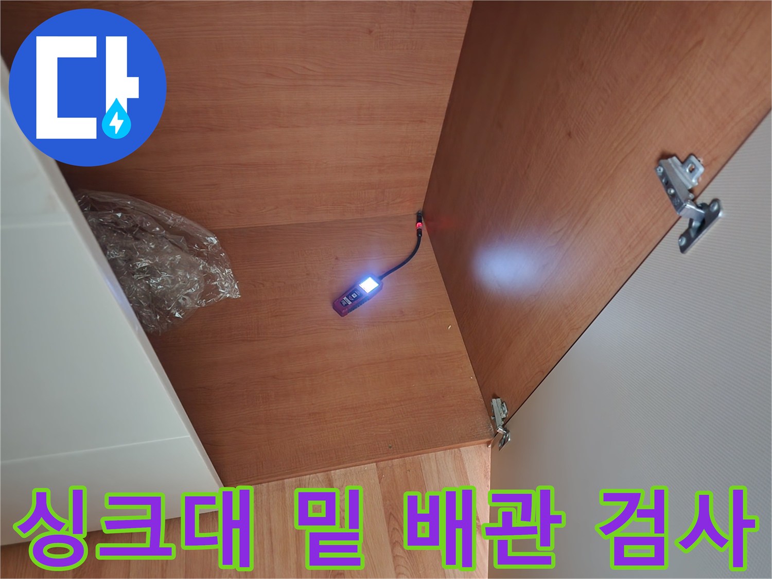 중랑구 면목동-싱크대 하부장 내부의 배관 주변을 내시경으로 조사하는 사진입니다.