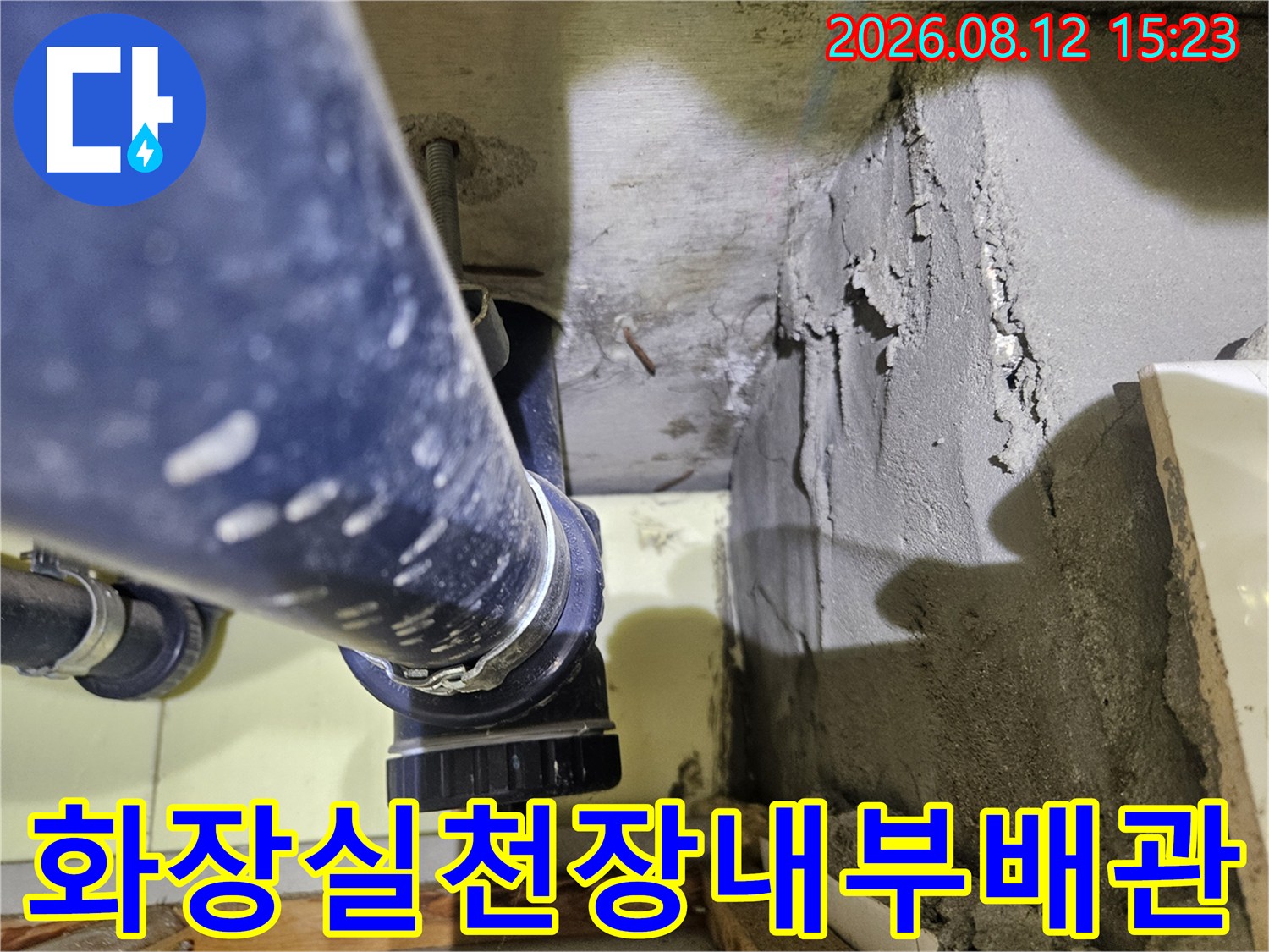 거칠게 마감된-시멘트 벽면과 파란색 배관의 연결 지점을 보여주는 사진