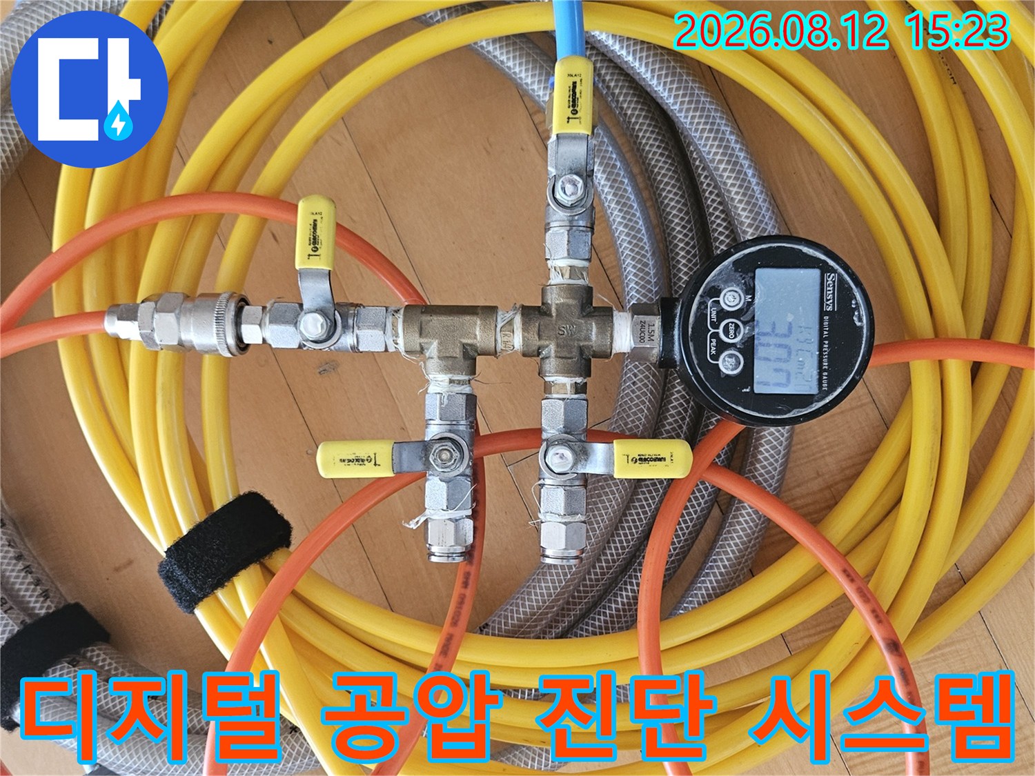 금속 매니폴드에 노란색과 파란색 호스가 연결된 누수 검사용 압력 측정 장치