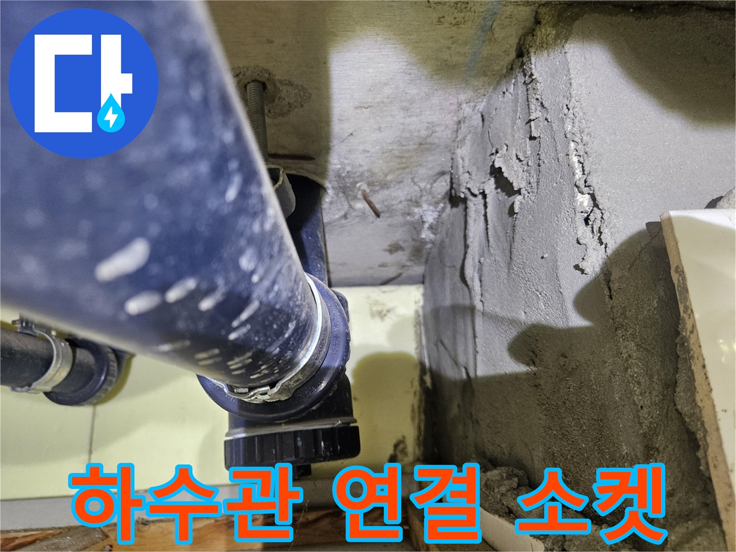 배관의 검은색 연결 부위와 콘크리트 벽면 근접 촬영