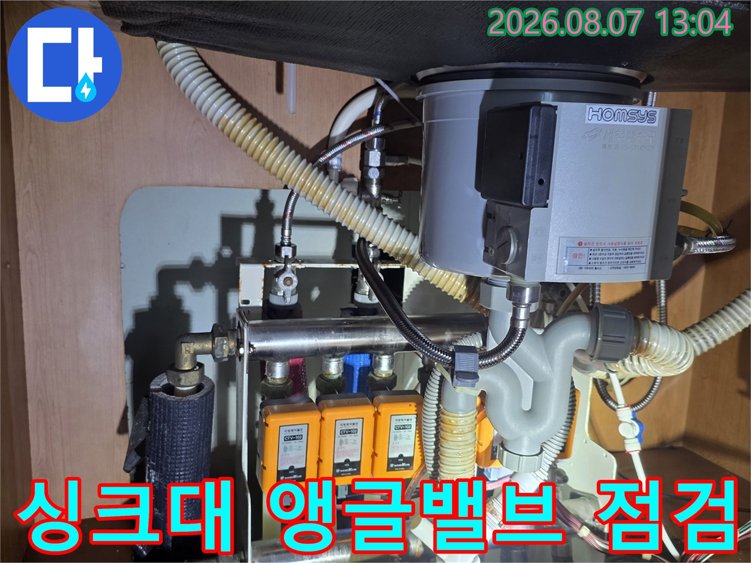 싱크대 아래 급수 밸브와 연결 호스의 근접 촬영