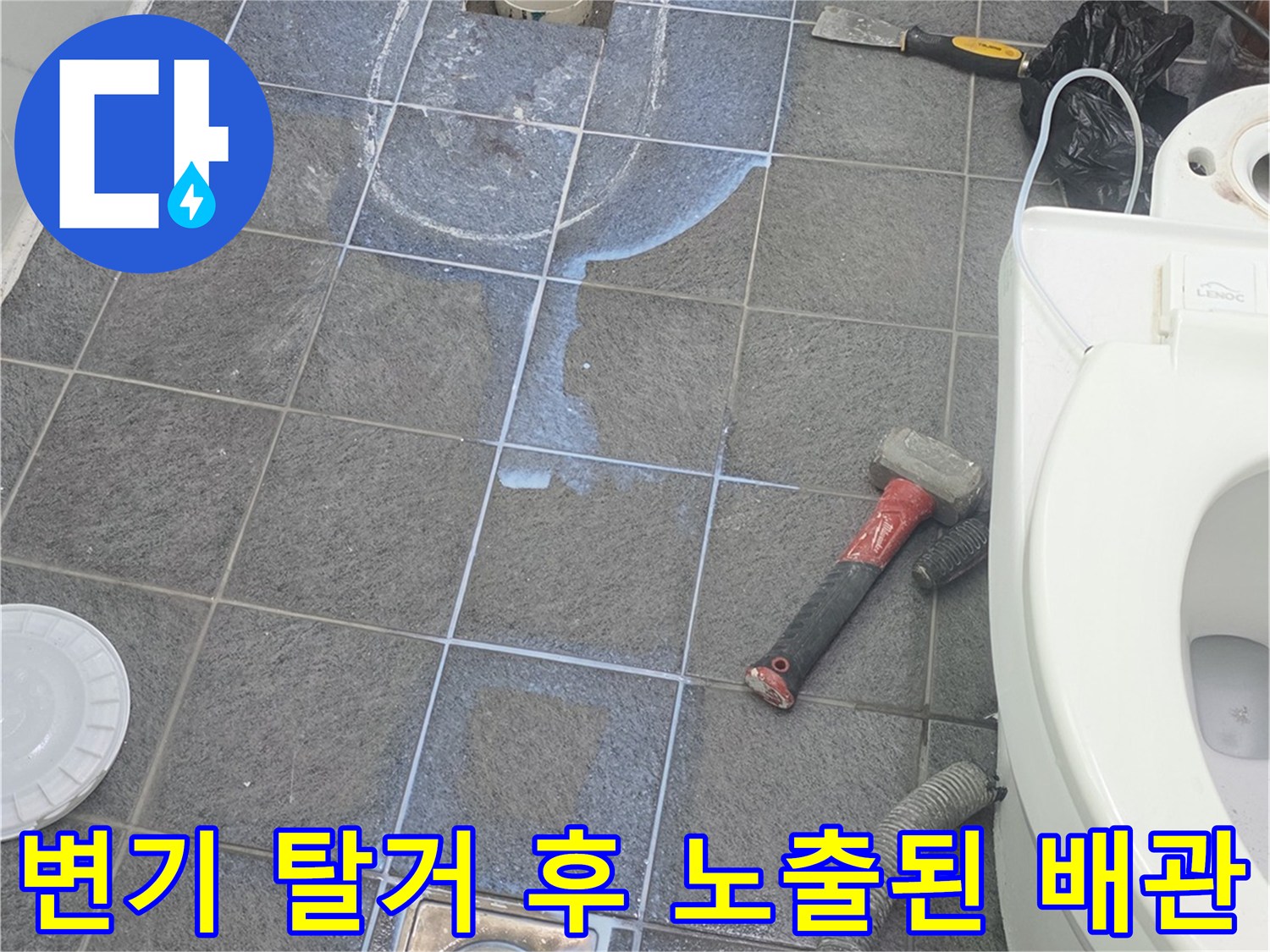 양변기를 들어낸 후 드러난 오염된 배관과 타일 바닥