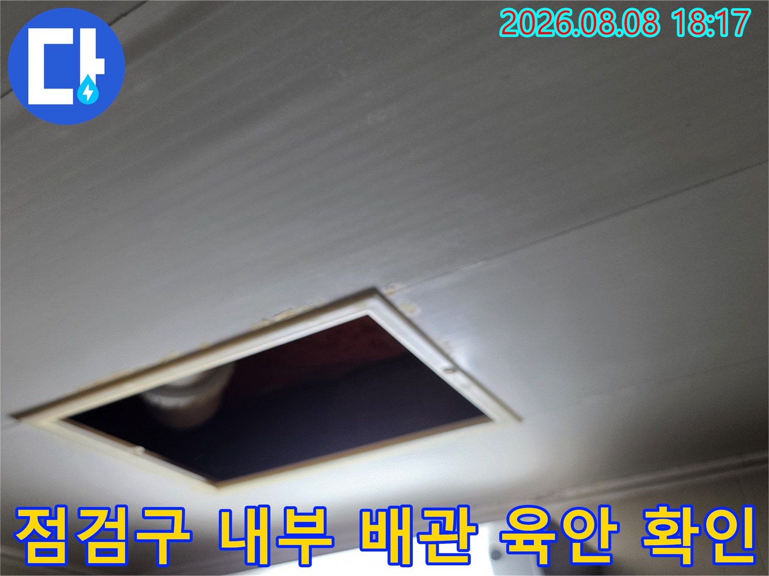 천장 점검구를 통해 배관의 연결 상태를 세밀하게 관찰하고 있습니다.