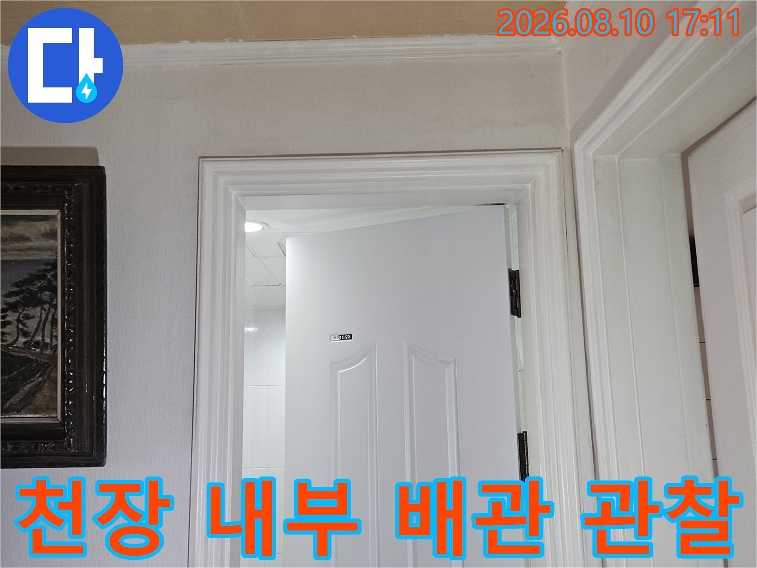 화장실 천장 점검구 안쪽의 하얀색 마감재와 배관 모습-누수 확인
