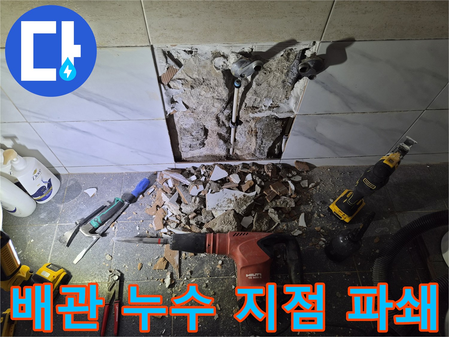 공사 중인 화장실 벽면-파손된 타일과 노출된 배관 연결부