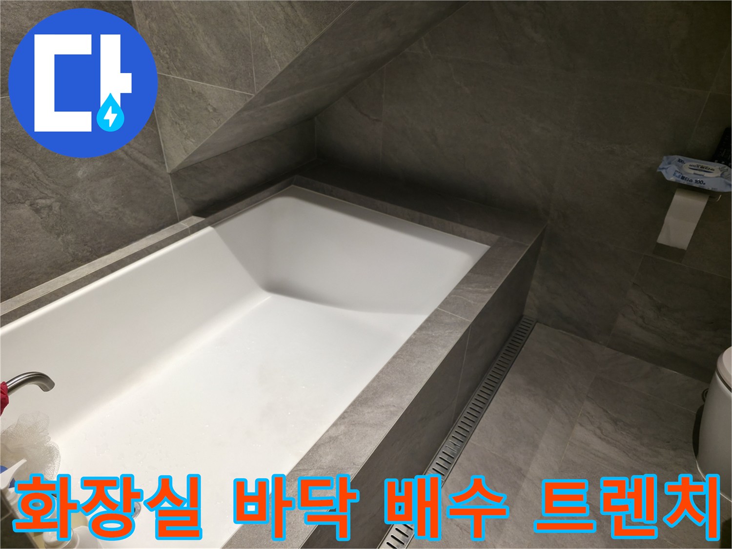 회색 타일로 이루어진 욕조 주변 배수 시설