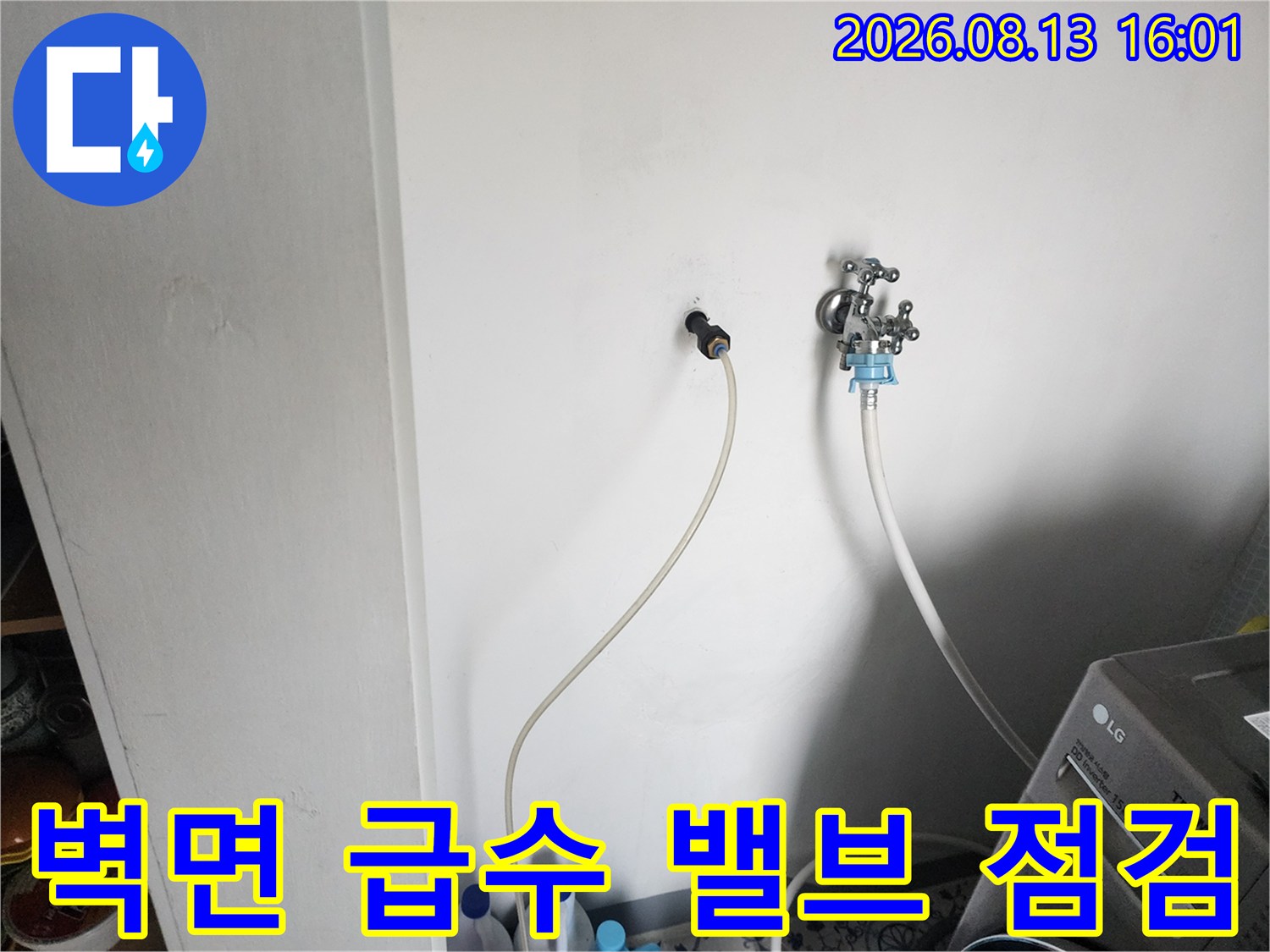 벽면에 돌출된 금속 재질의 급수 밸브와 연결 호스 상세 사진입니다.