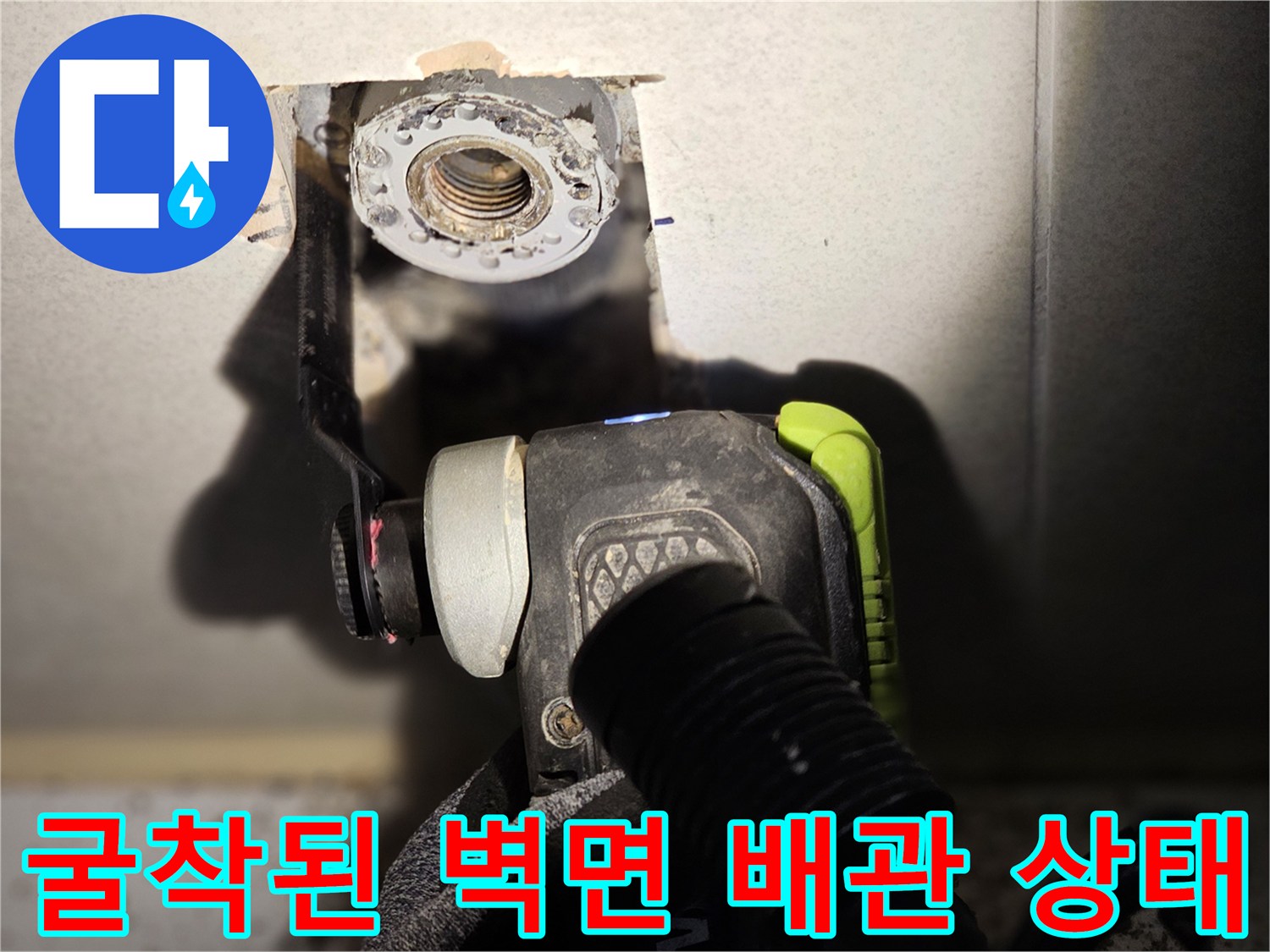 벽면 굴착을 통해 드러난 금속제 배관 연결 부위와 주변 마감재 모습입니다.