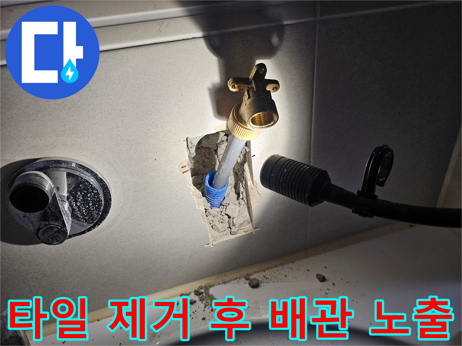 벽면 타일을 걷어내고 드러난 수도 연결 부위와 황동 부속