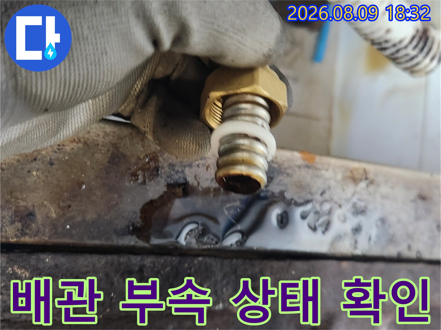 새로 준비된 밸브-장갑을 낀 손으로 부품의 나사산 부분을 세밀하게 살피고 있습니다.