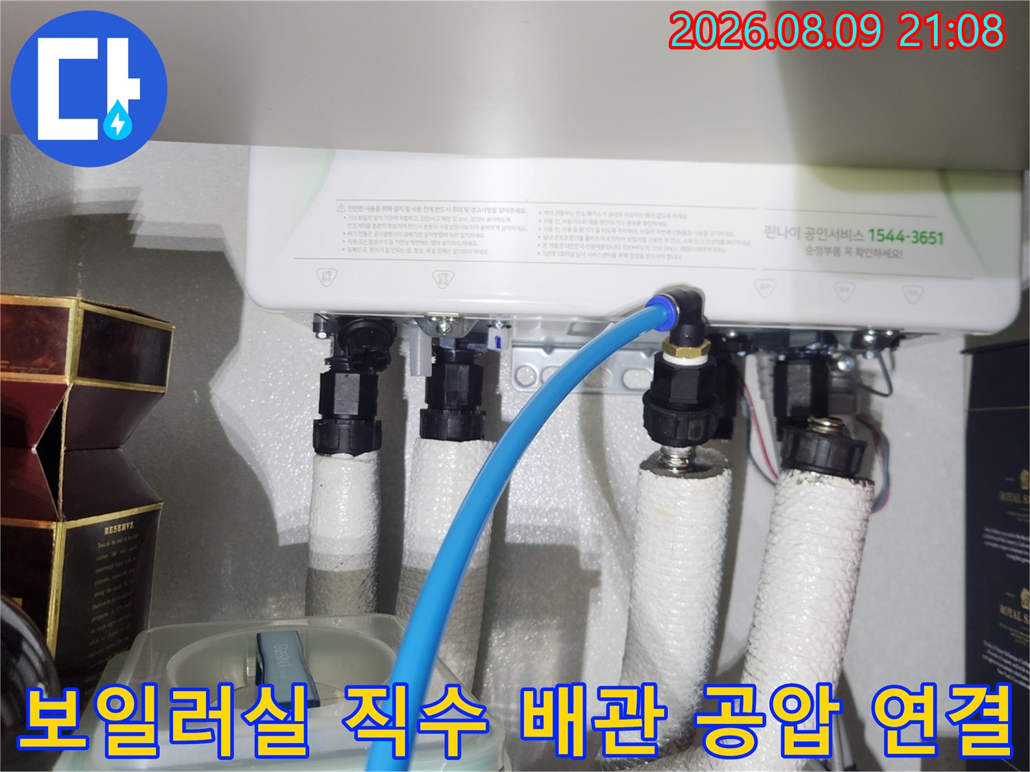 흰색 보온 마감재가 적용된 배관에 파란색 측정용 호스가 연결되어 있는 사진