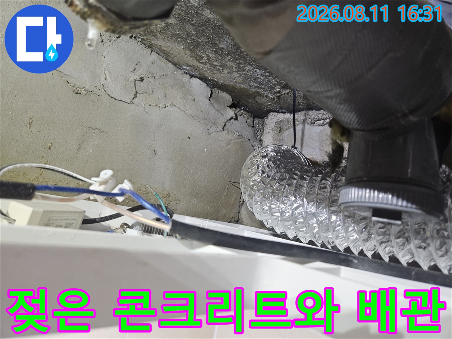 습기를 머금은 콘크리트 면과 은색 보온재가 씌워진 배관의 모습입니다.