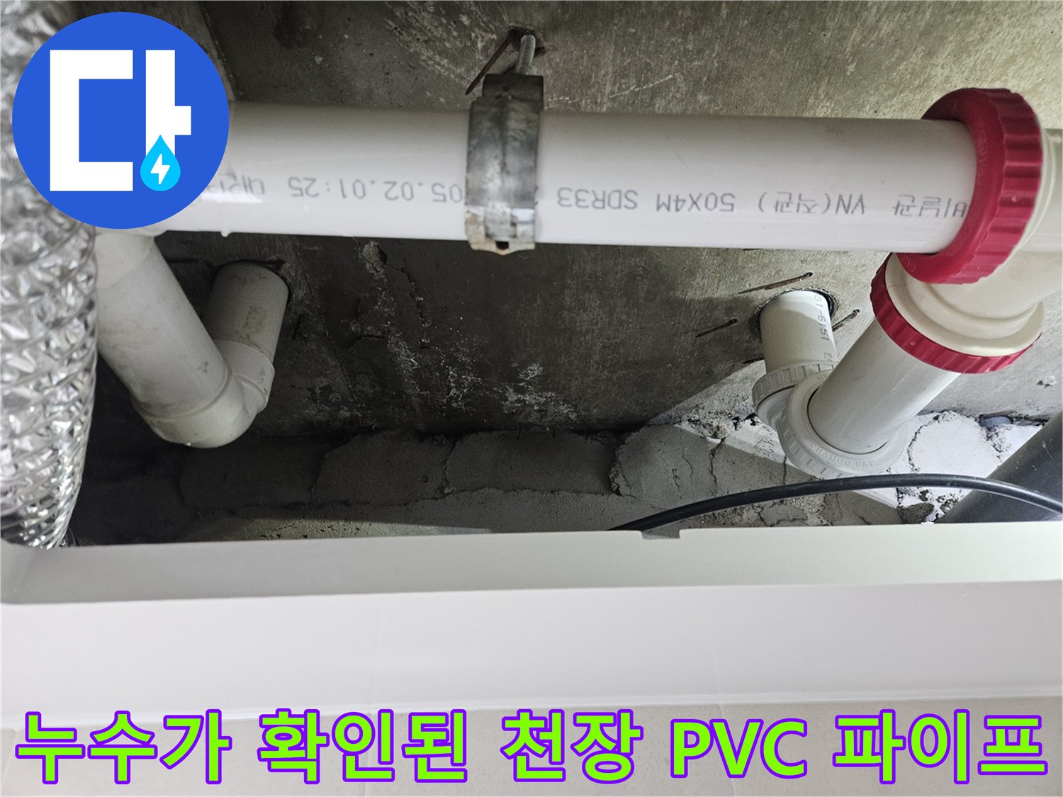화장실 천장에 매달린-흰색 PVC 하수 배관과 빨간색 연결 부품 모습