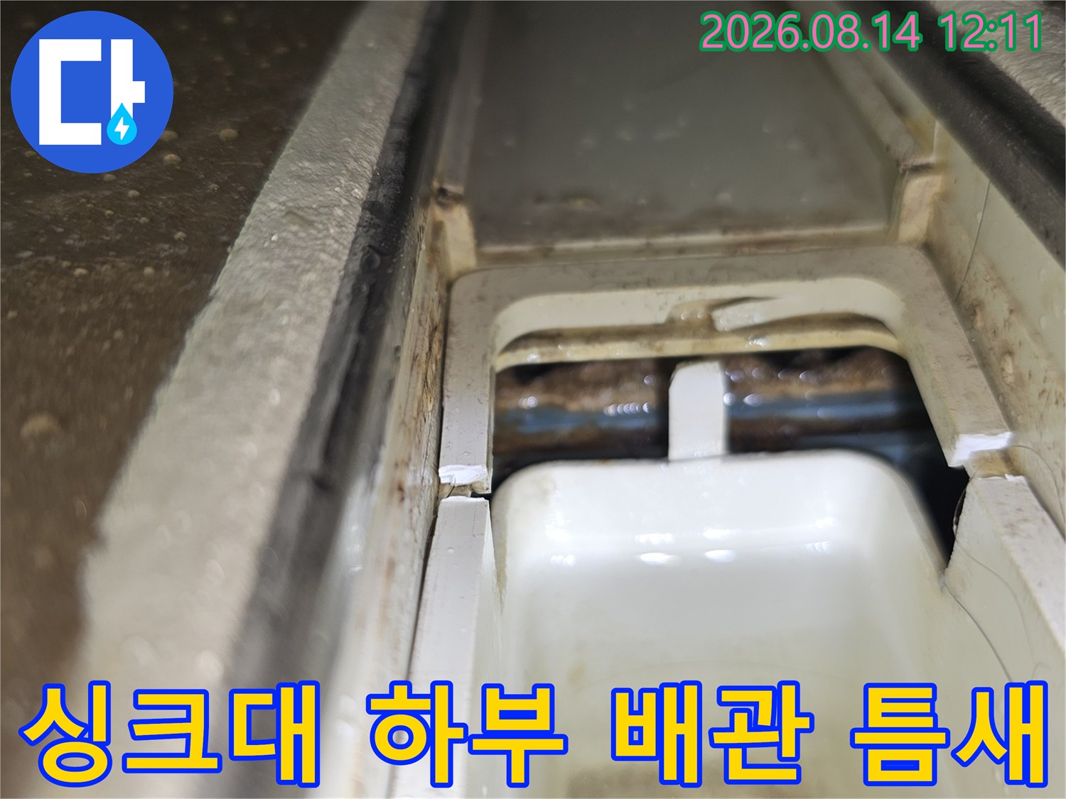 싱크대 하부의 배관 연결 부위와 구조물 사이 틈을 촬영한 모습입니다.